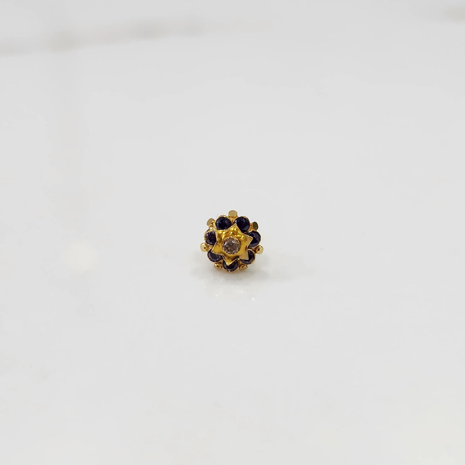 Gold flower ring with purple gemstones and gold star center