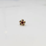 Top view of gold ring with ruby-red center stone and prong-set petals