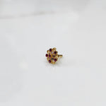 Gold flower ring with red and clear gemstones in halo setting