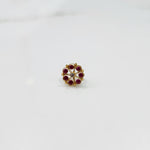 Front view of gold ring with red gemstone petals
