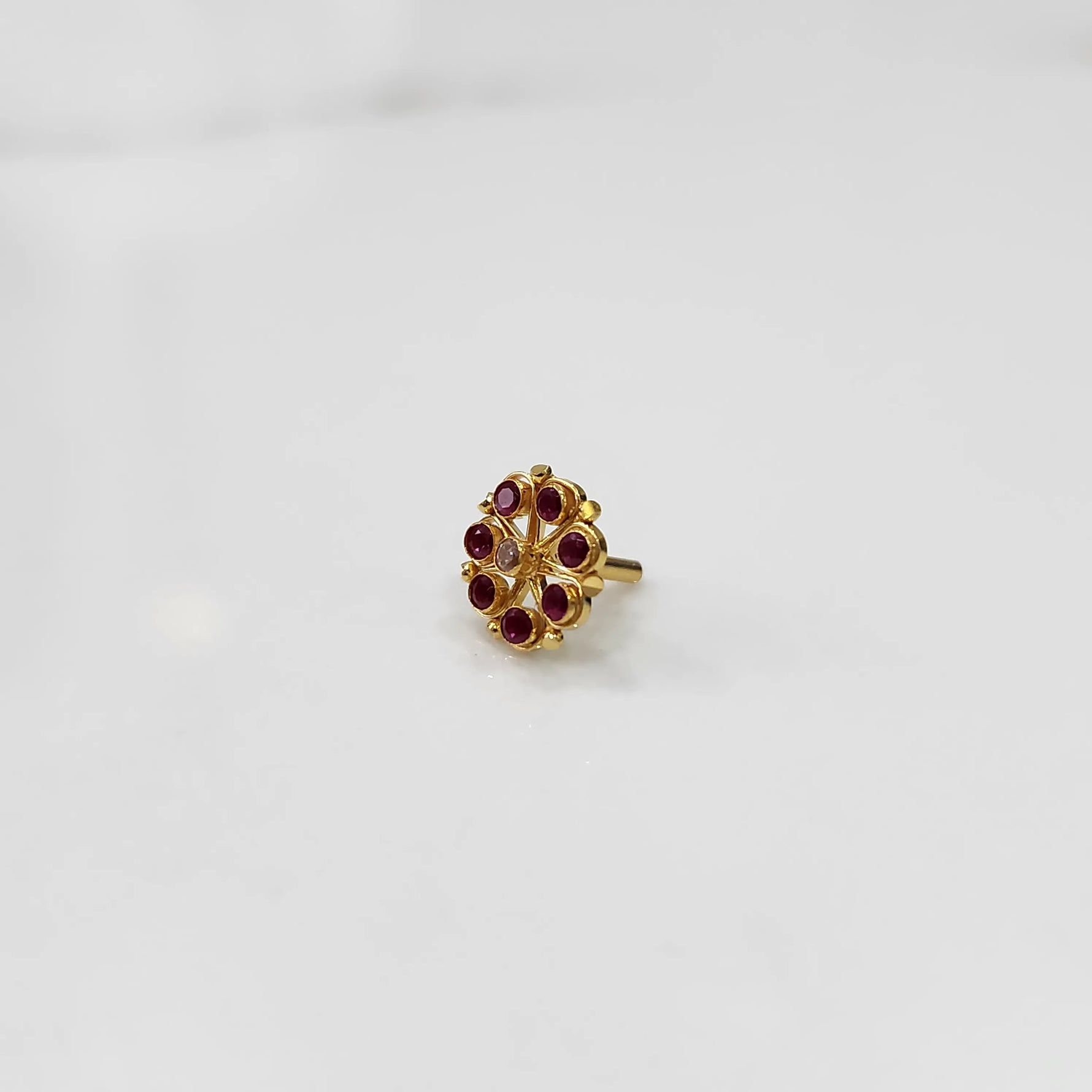 Gold flower ring with red gemstones, front view