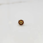 Gold flower ring with red gemstones and gold star center