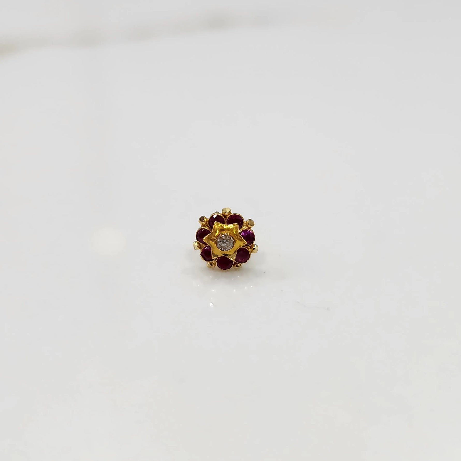 Gold flower ring with red gemstones and gold star center