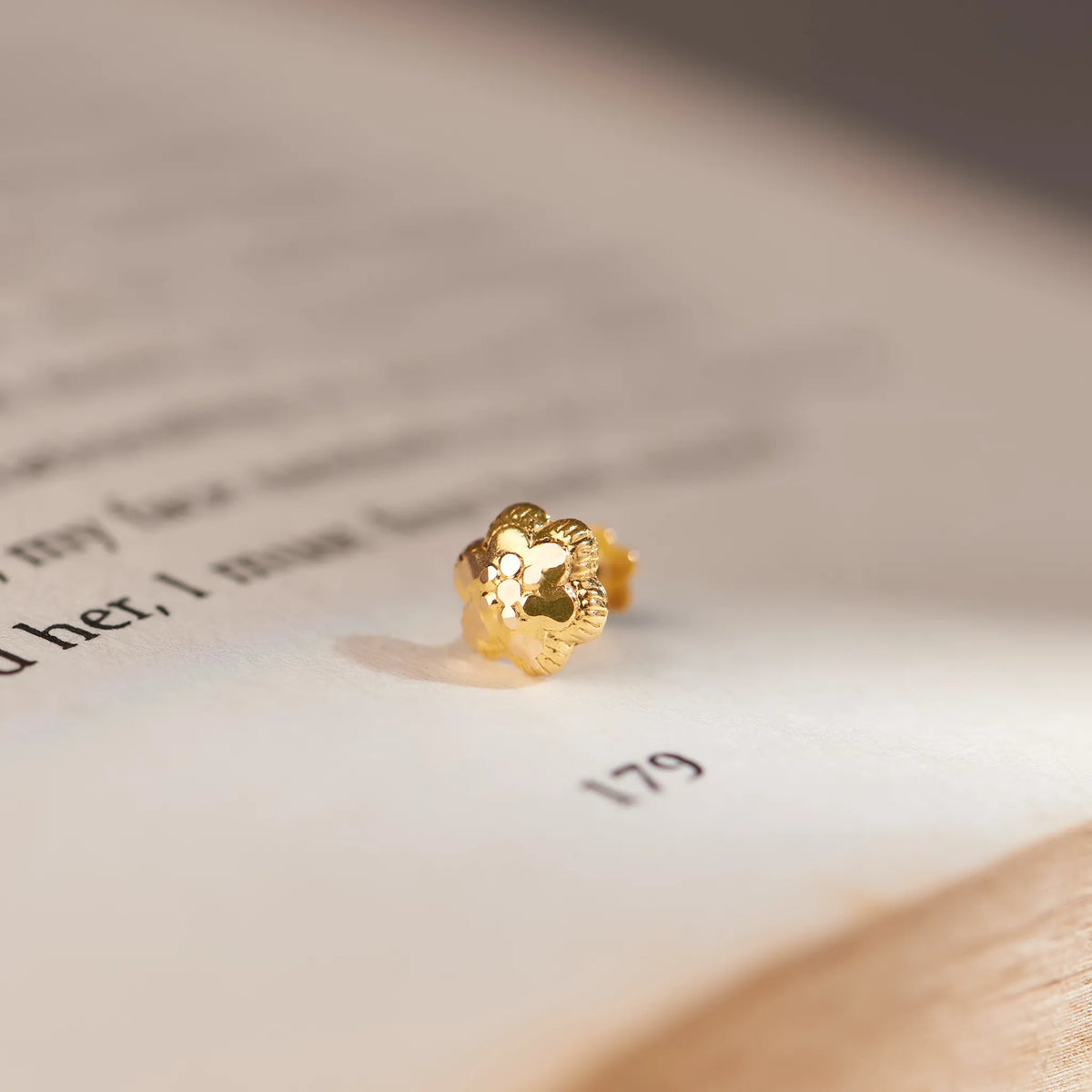 Solid gold flower-shaped stud earring, macro close-up shot