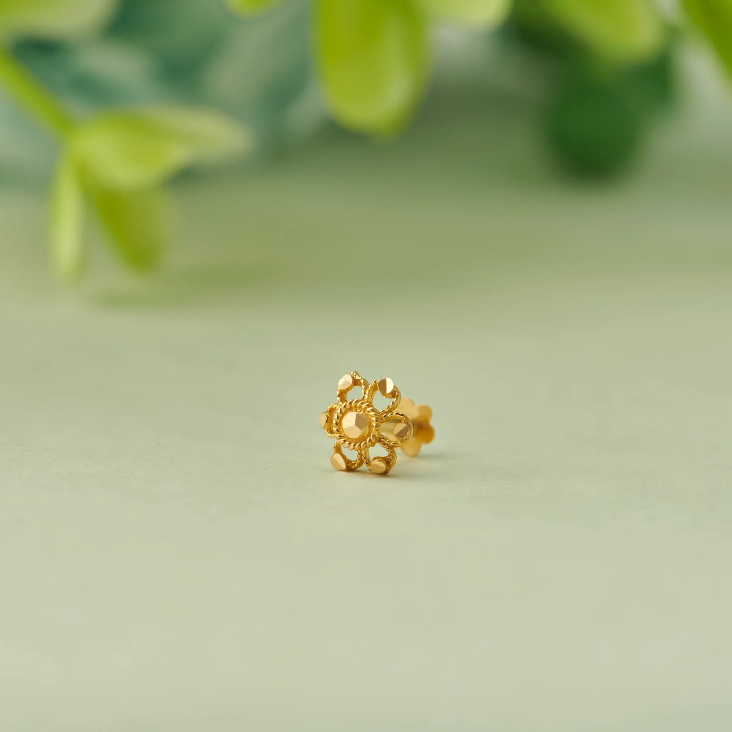 Gold flower-shaped stud earring with textured petal design
