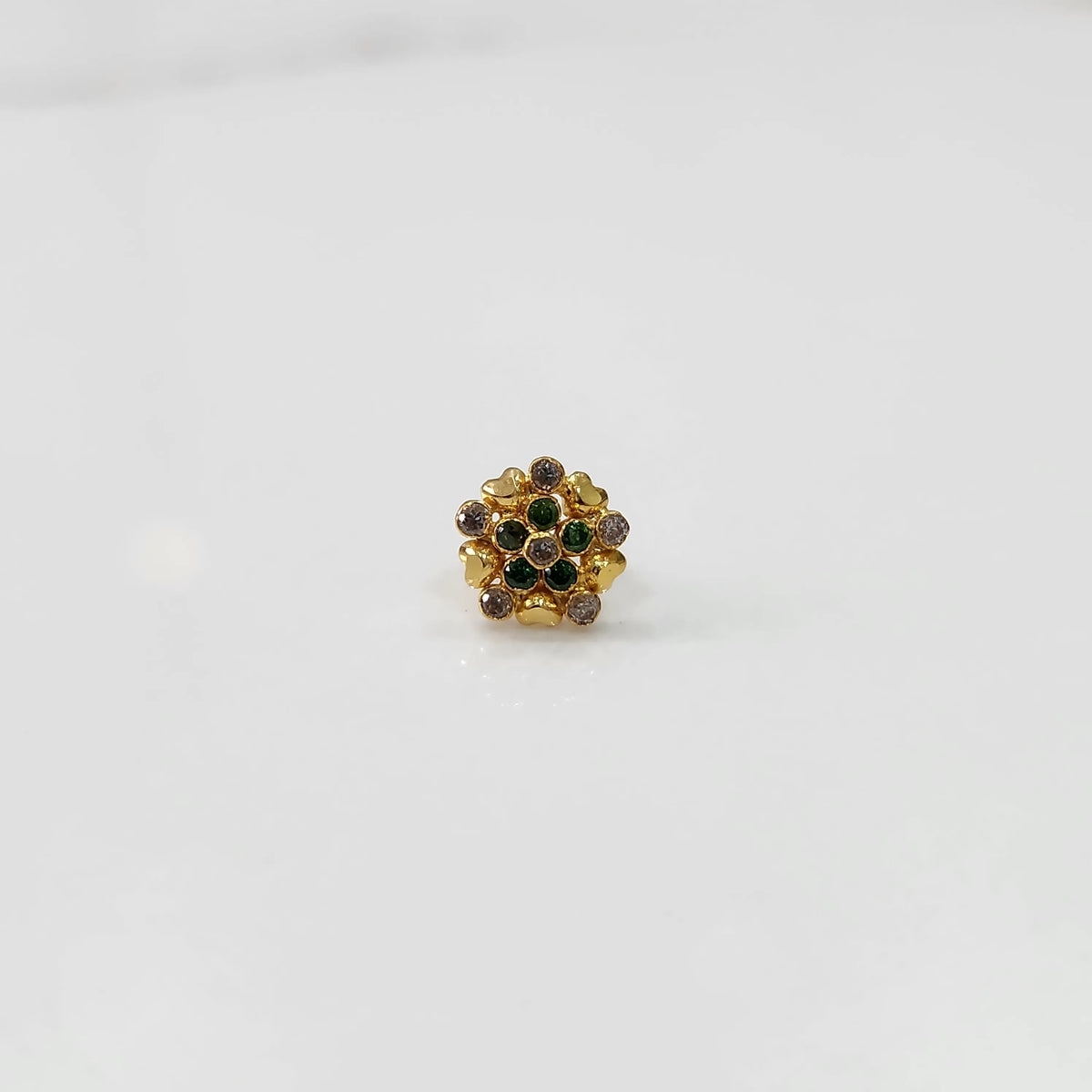 Gold statement ring with green and brown gemstones in textured floral cluster design