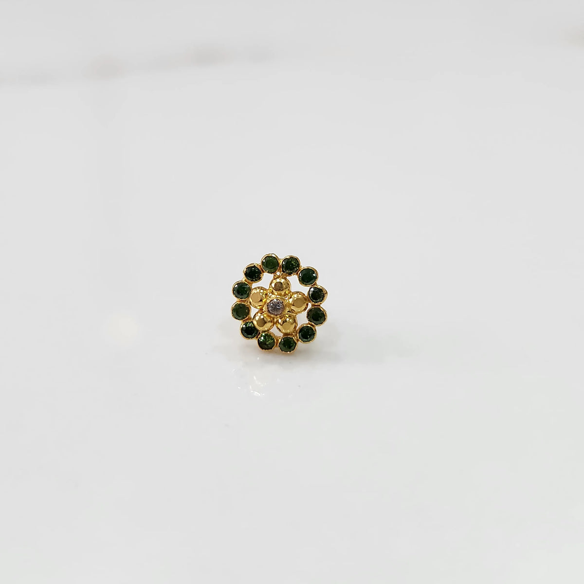 Gold floral nose pin with green stone halo, product shot