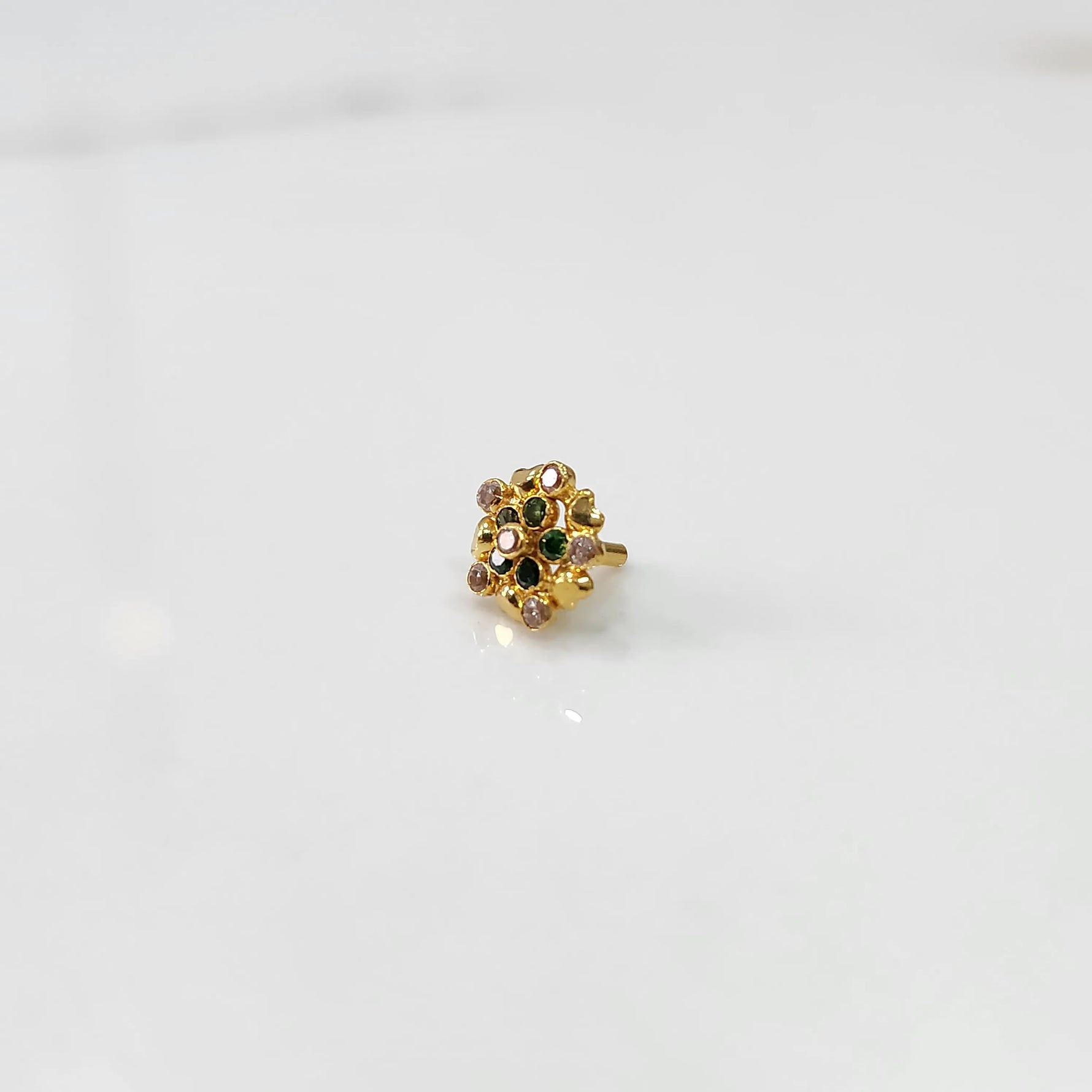 Gold statement ring with green and multicolor gemstones in textured floral cluster design