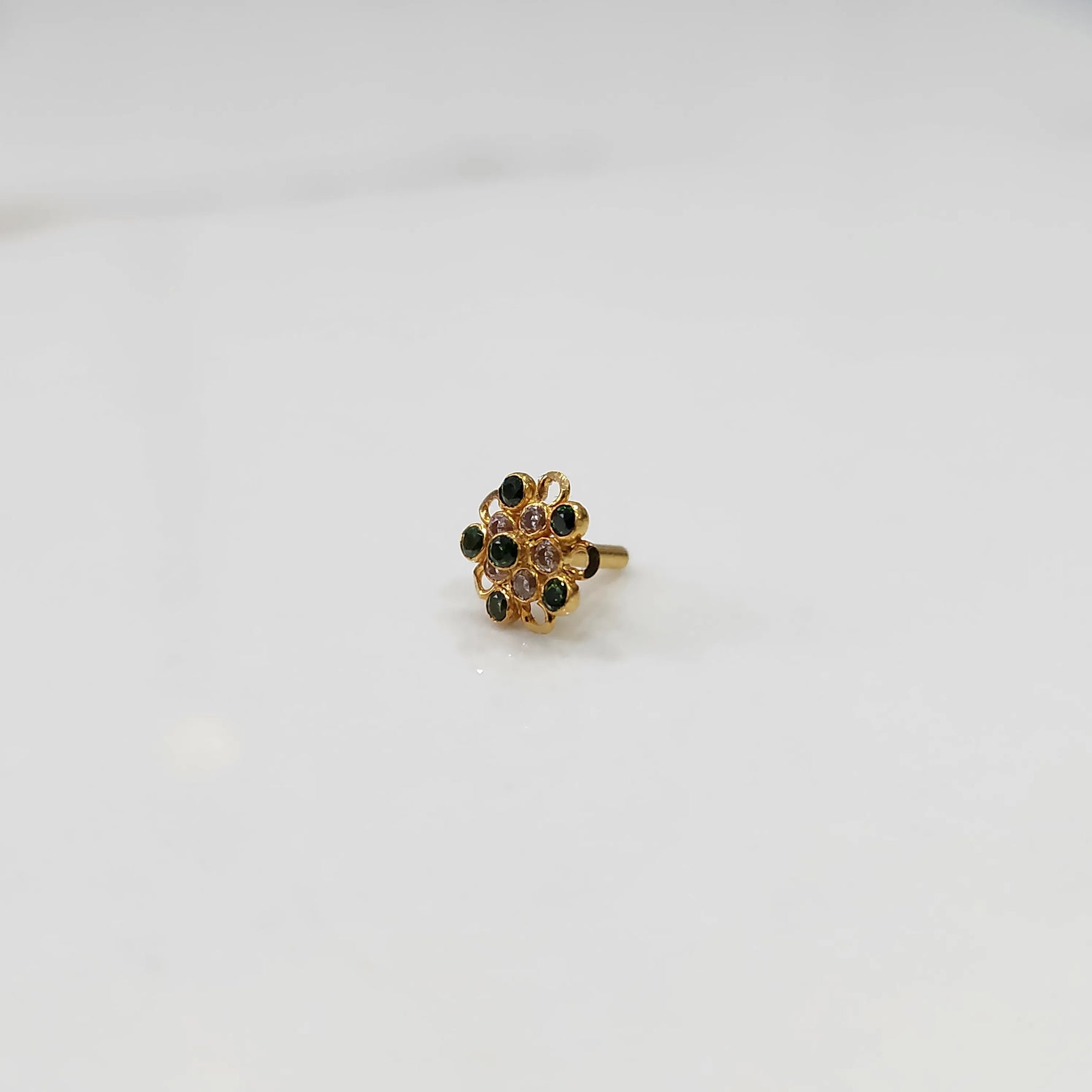 Gold nose pin with green and pink gemstone mandala design on white background
