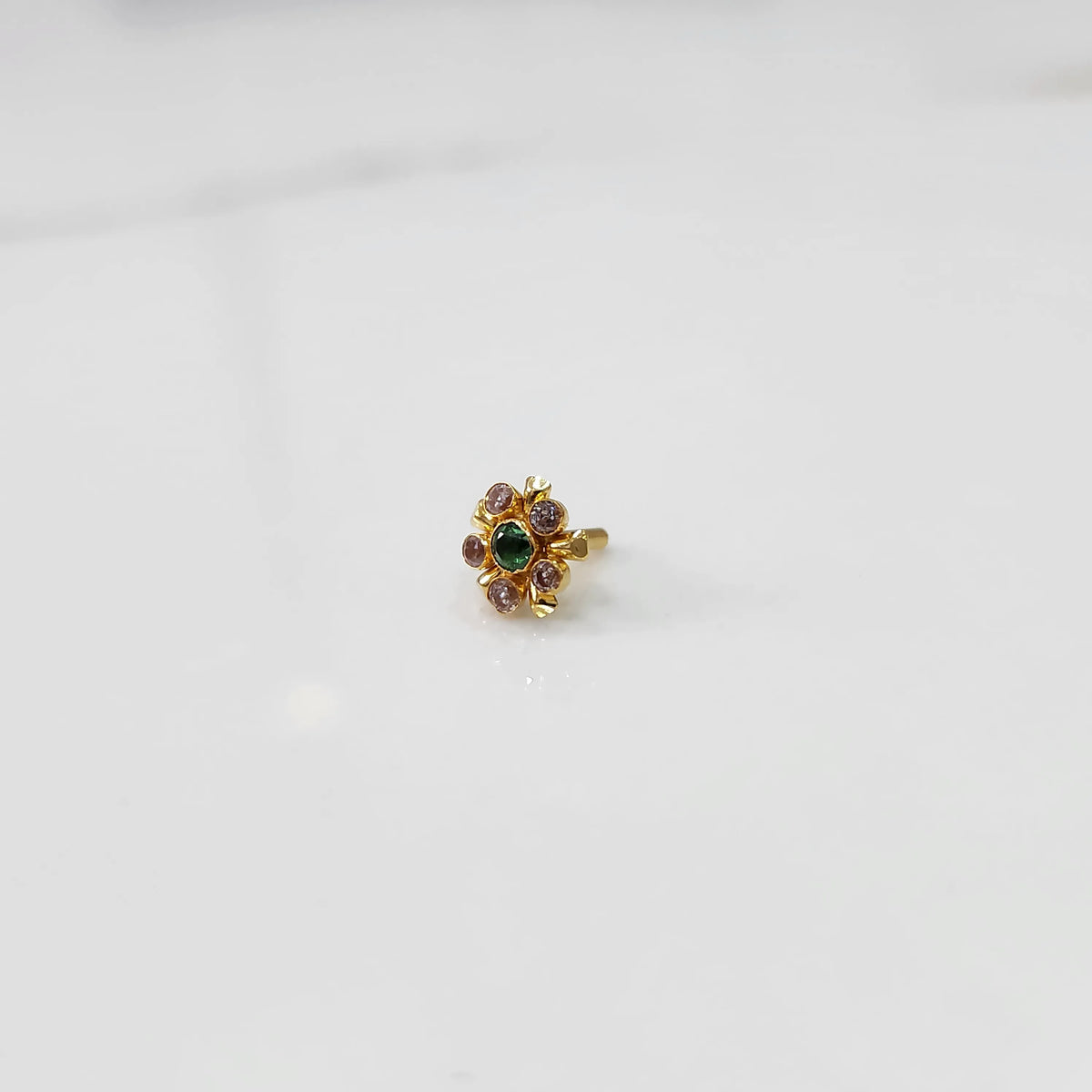 Gold statement ring with green and pink gemstones in floral cluster setting