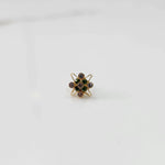Gold statement ring with green and purple gemstones in floral atomic design