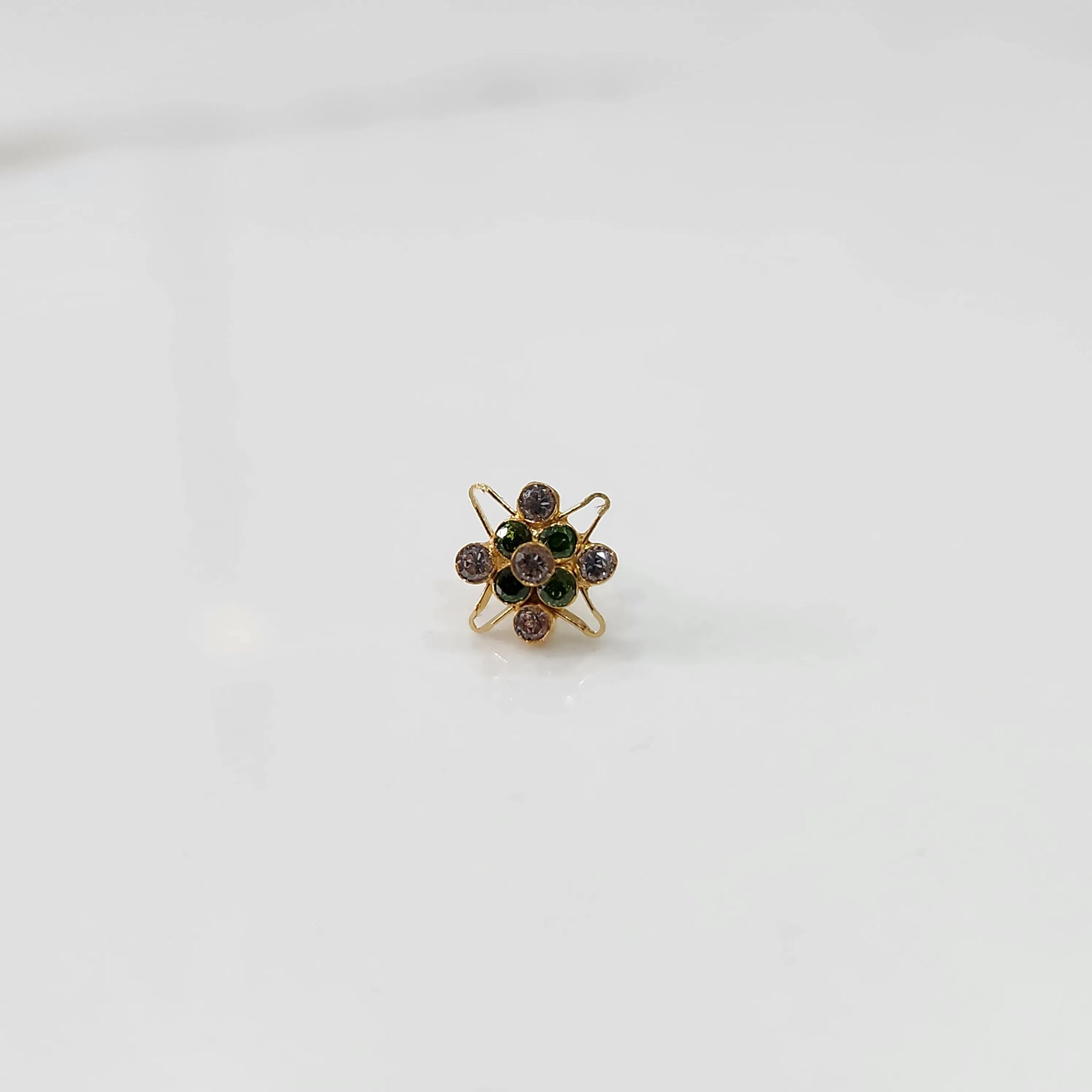 Gold statement ring with green and purple gemstones in floral atomic design