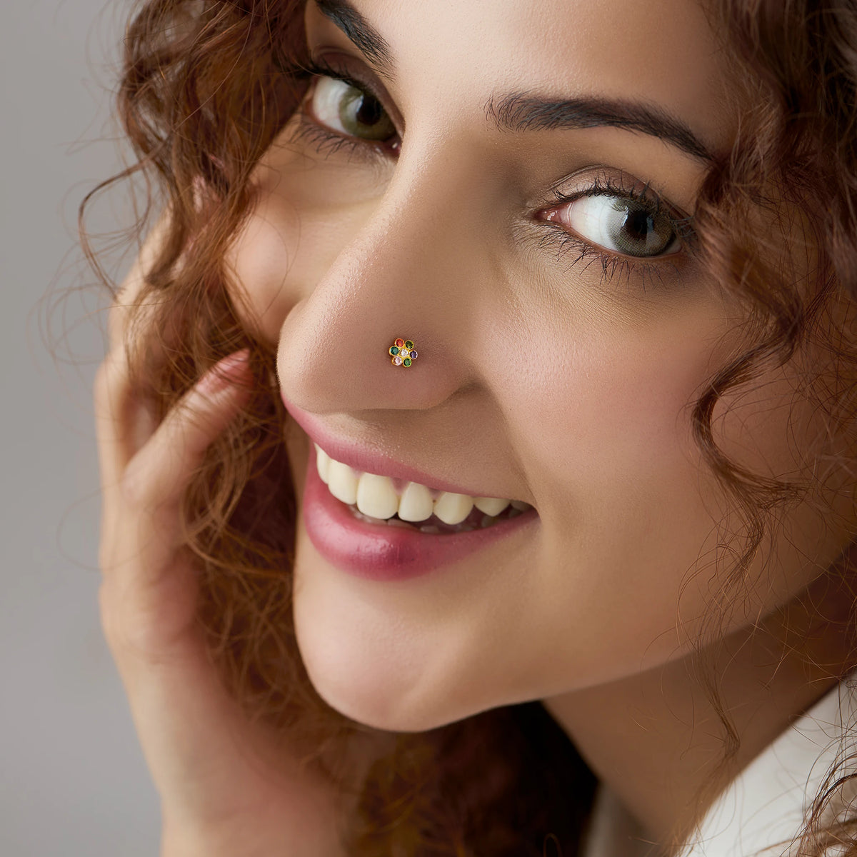 Woman wearing nose pin design gold with floral stone pattern close up