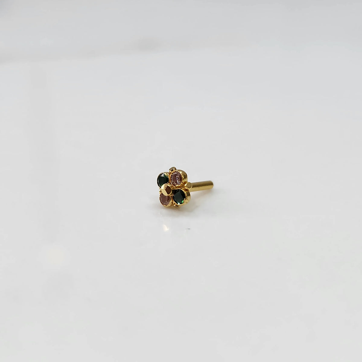 Gold floral nose pin with green and pink stones, product shot