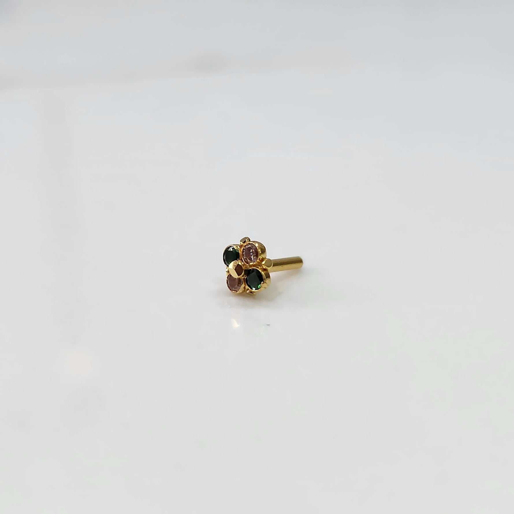 Gold floral nose pin with green and pink stones, product shot