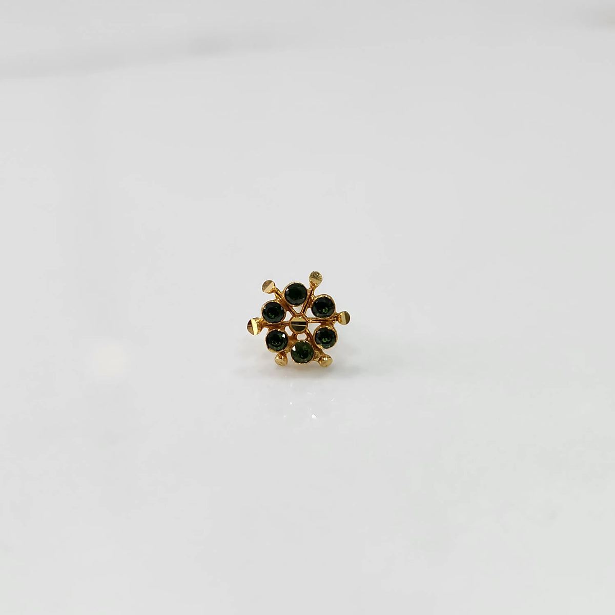 Front view of gold statement ring with green gemstones in scattered dotted cluster design