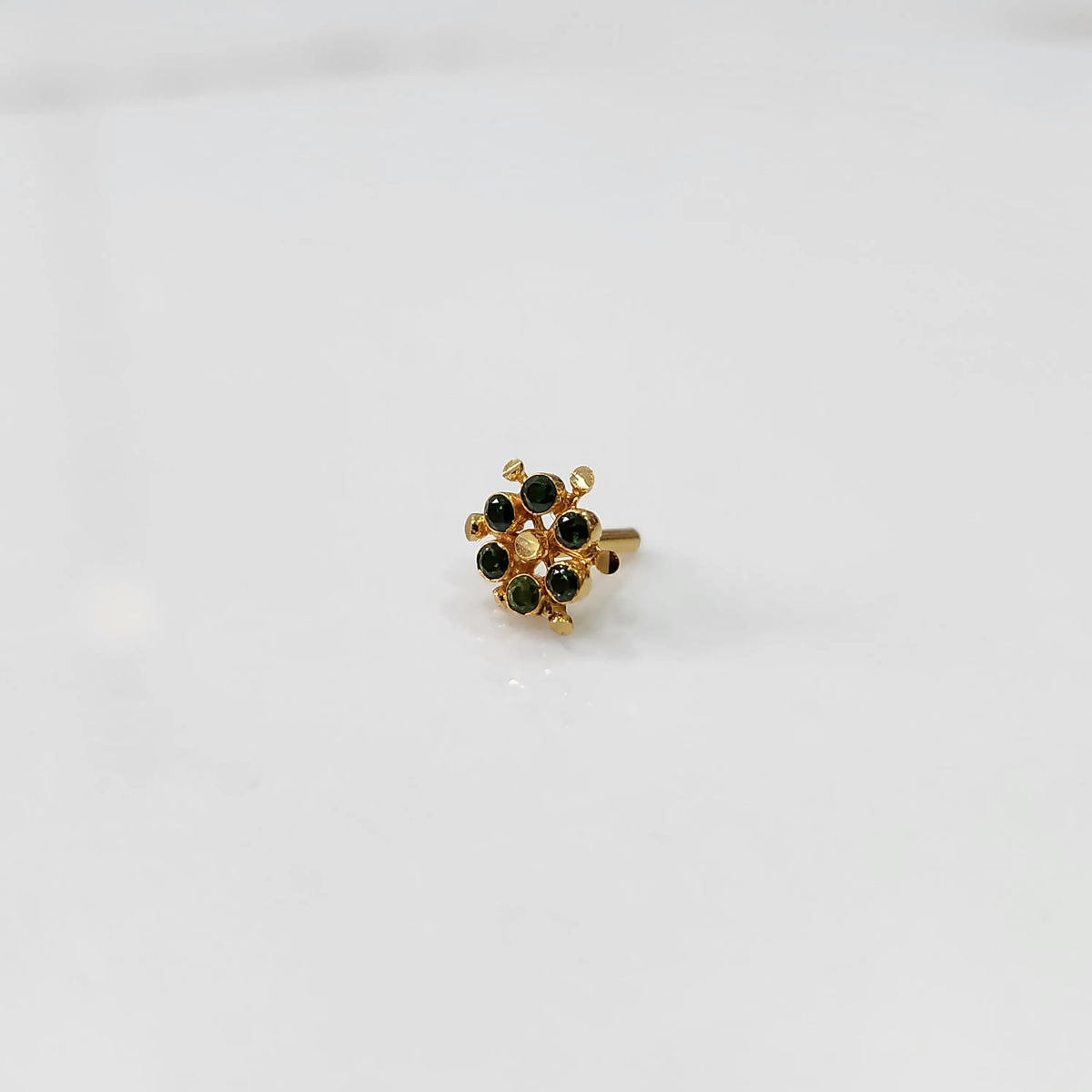 Gold statement ring with green gemstones in scattered dotted cluster design