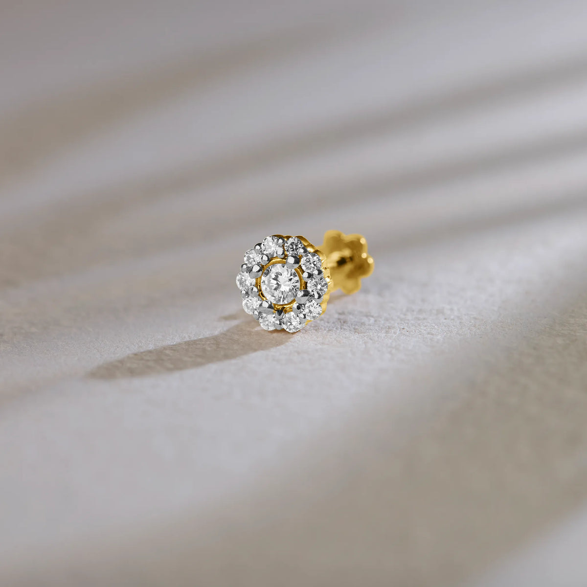 Round halo lab grown gold nose pin with center diamond on soft background