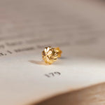 Gold clover-shaped stud earring with heart-petal design, close-up