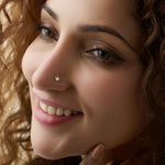 Elegant gold nose pin with heart-accent diamond detail, jewelry close-up