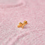 Gold heart-shaped nose stud with looped design on pink glitter background