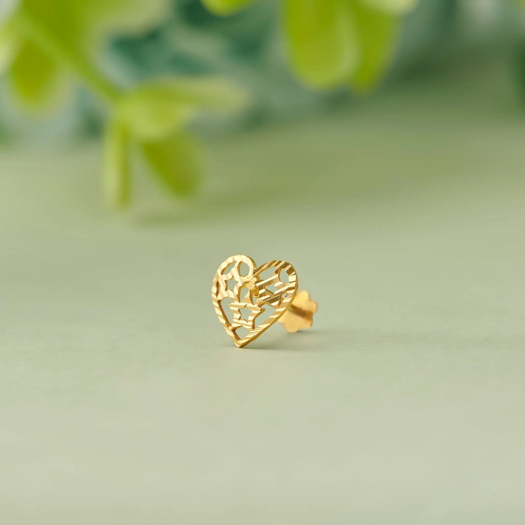 Gold heart-shaped stud earring with filigree cutout design