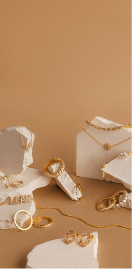 Gold jewellery collection displayed on stone props