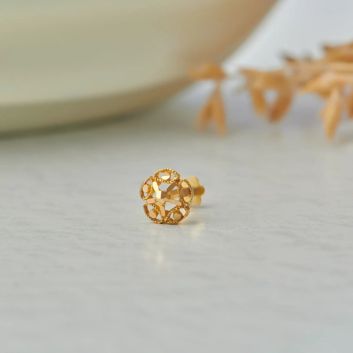 Gold stud earring with open lattice flower design