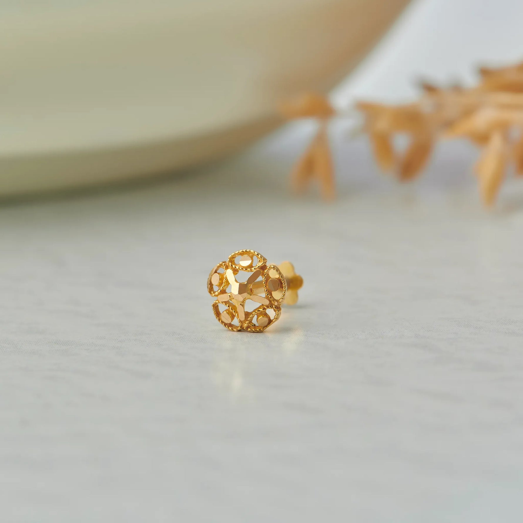 Gold stud earring with open lattice flower design