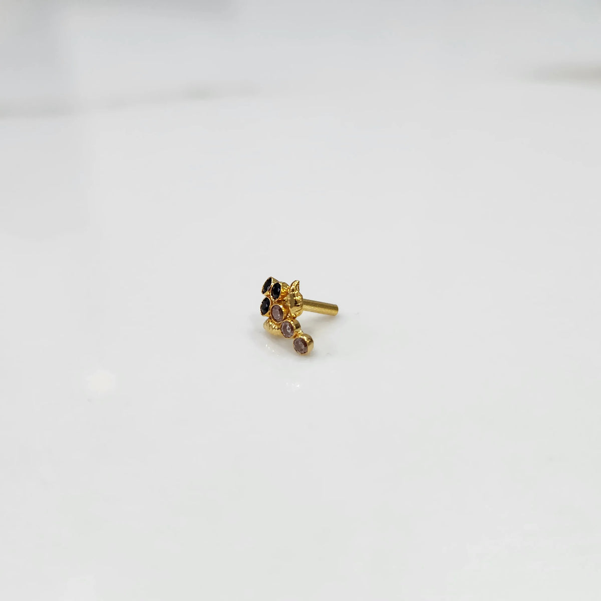 Gold ring with black and purple gemstone leaf-charm cluster design, side view