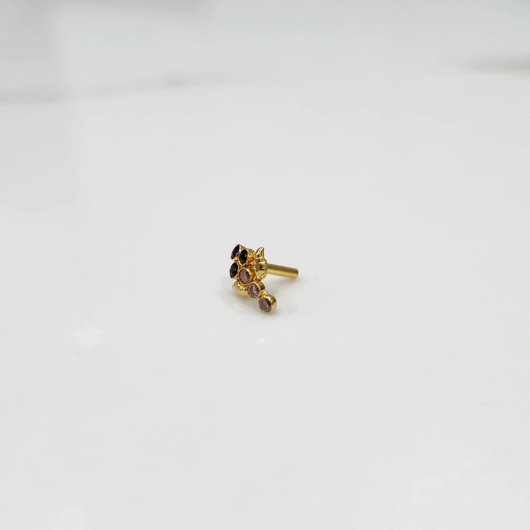 Gold ring with black and purple gemstone leaf-charm cluster design, side view