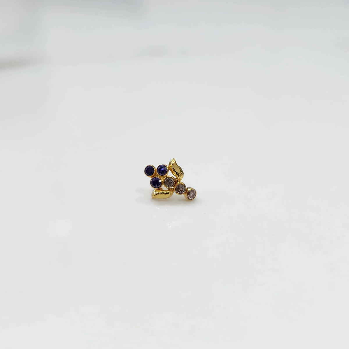 Antique-style gold ring with blue-toned stones in leaf-charm pattern