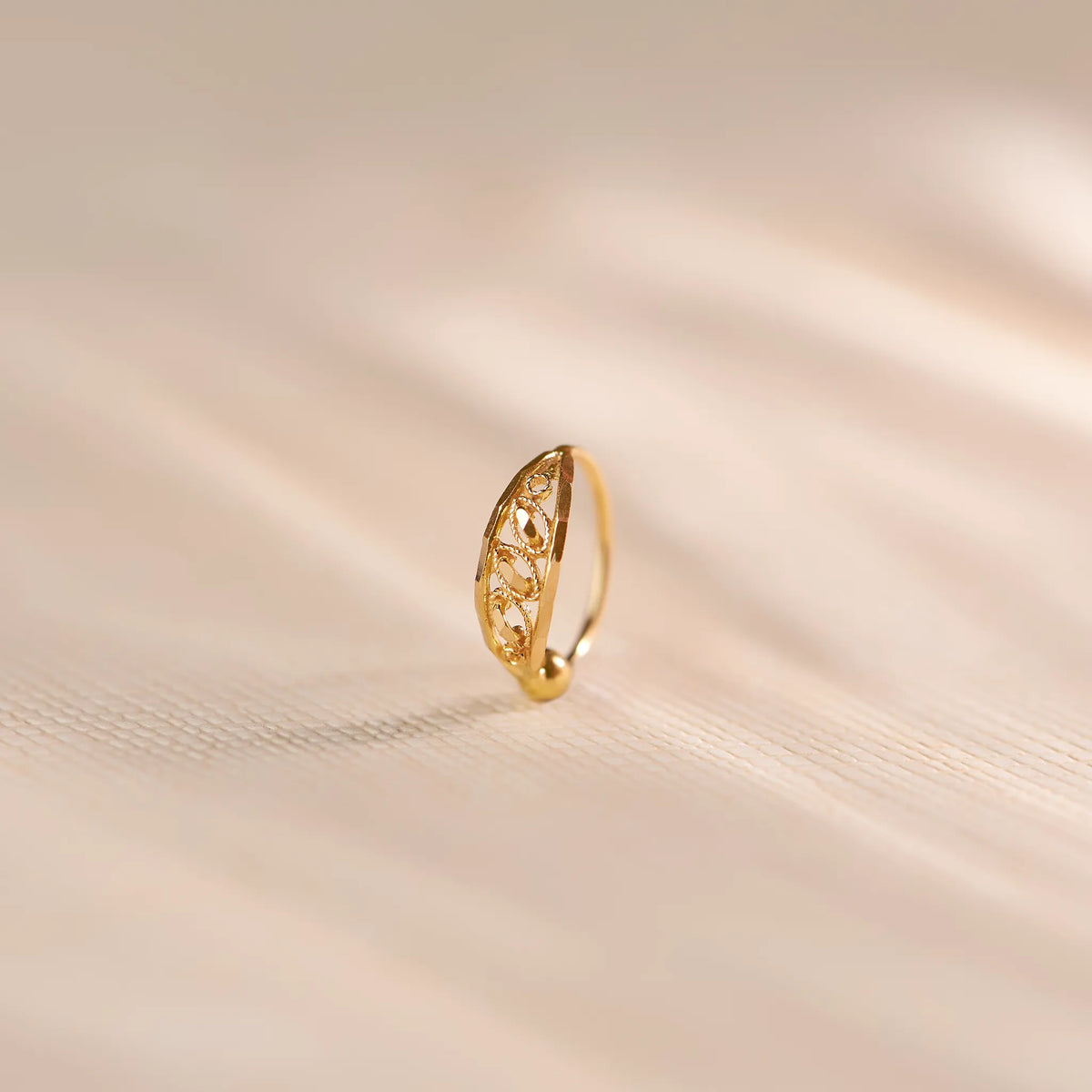 Gold nose ring with ornate filigree marquise design, ball detail
