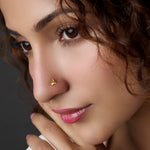 Woman wearing a leaf-shaped gold nose pin