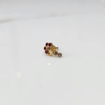 Gold nose pin with magenta gemstone cluster and clear drop-style stone accent on white background