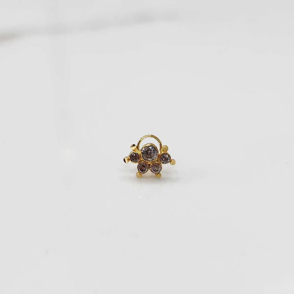 Traditional gold ring featuring an asymmetric five-stone gemstone design