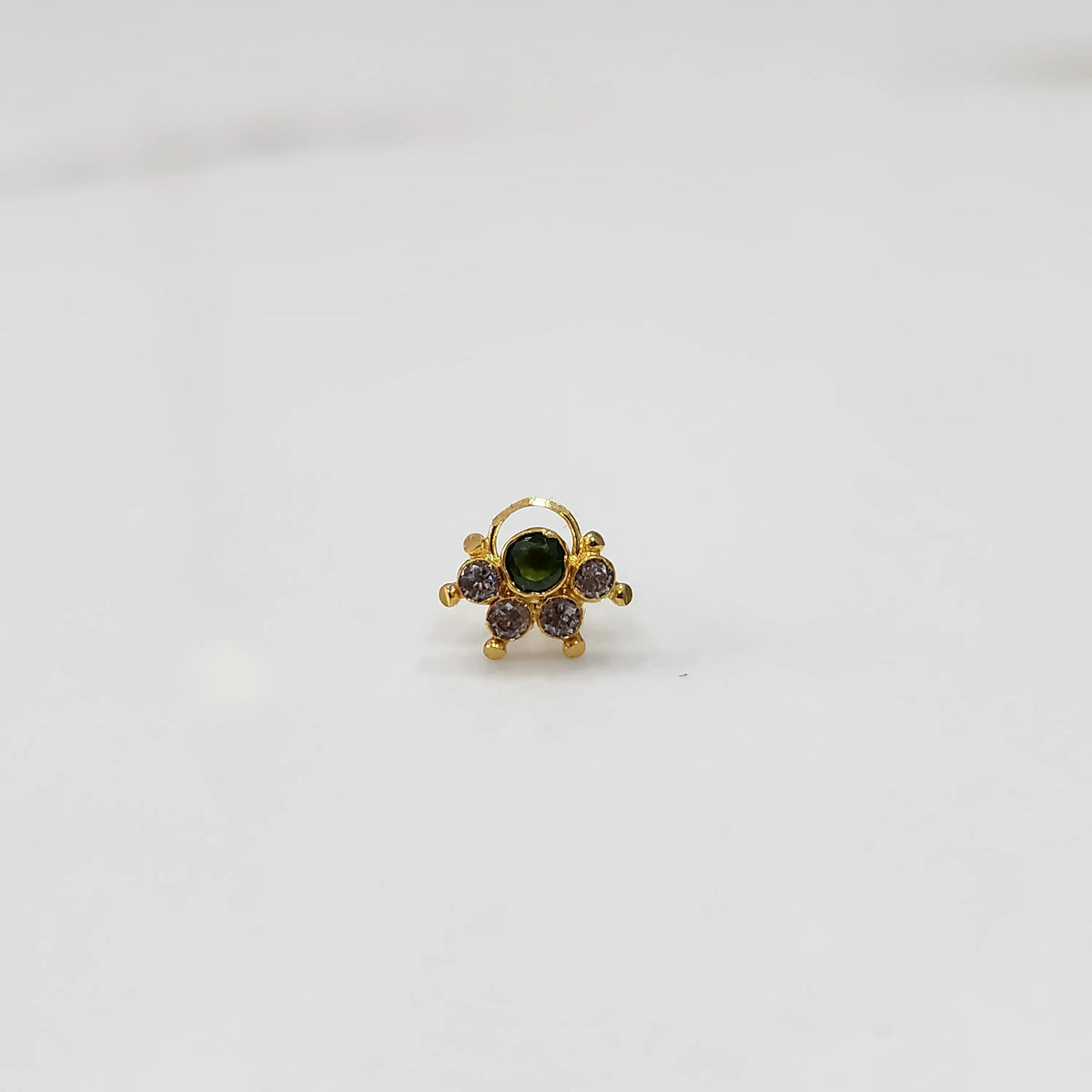 Front view of gold ring with green center stone and pink accents