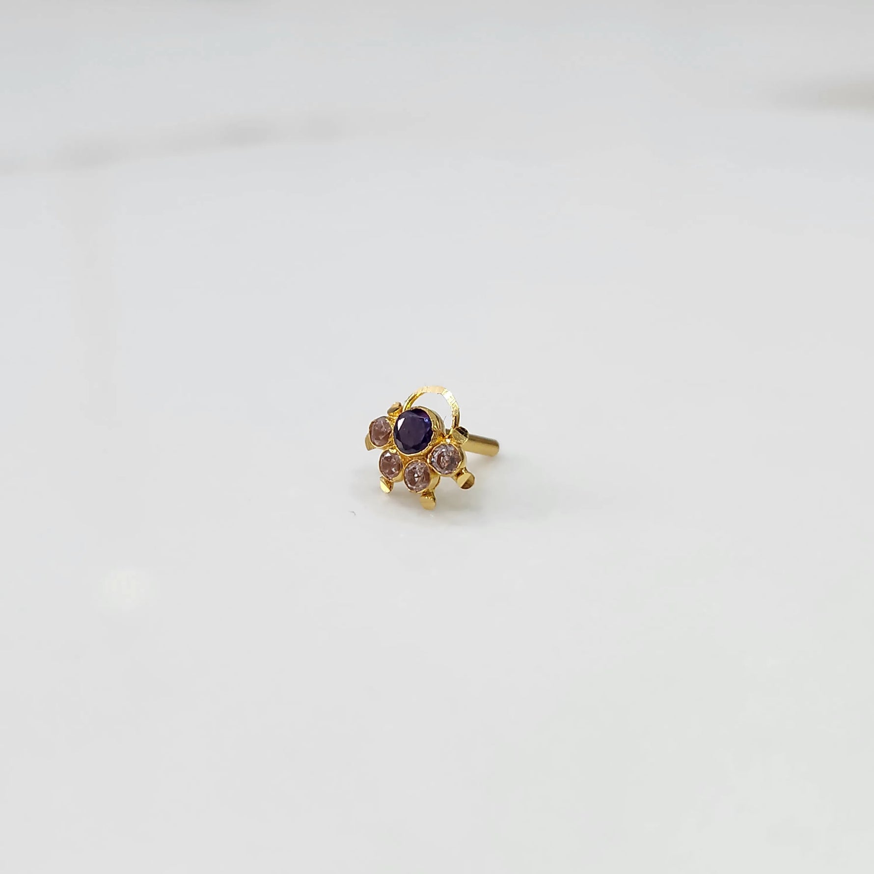 Gold ring with purple round center stone and champagne accents