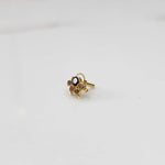 Gold ring with purple oval center stone and champagne accents