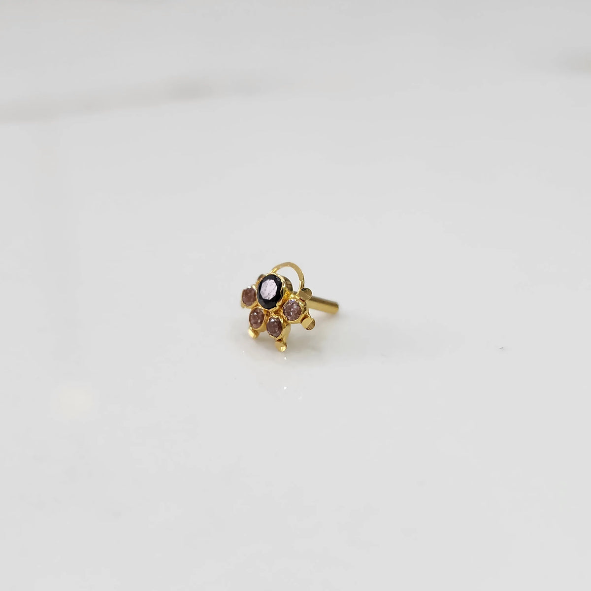 Gold ring with purple oval center stone and champagne accents