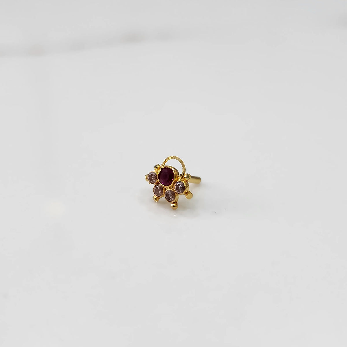Gold ring with ruby-red round center stone and pink accents