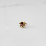 Gold ring with ruby-red round center stone and pink accents