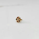Gold nose pin with multicolor gemstone petals and clear center stone on white background