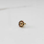 Large gold nose pin with multicolor gemstone flower ring design on white background