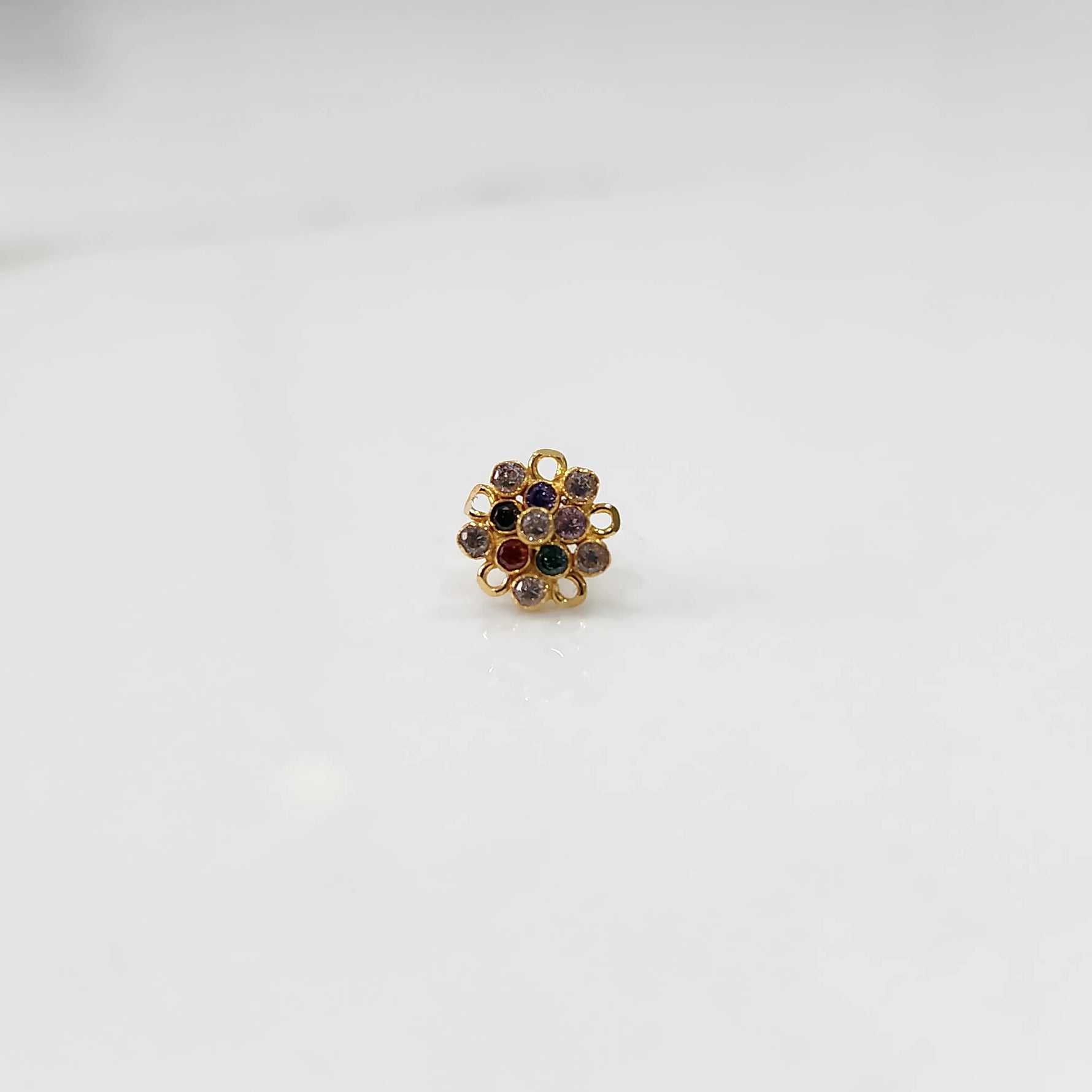 Front view of gold nose pin with multicolor gemstone mandala design on white background