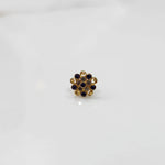Gold flower ring with purple and clear gemstones in halo setting