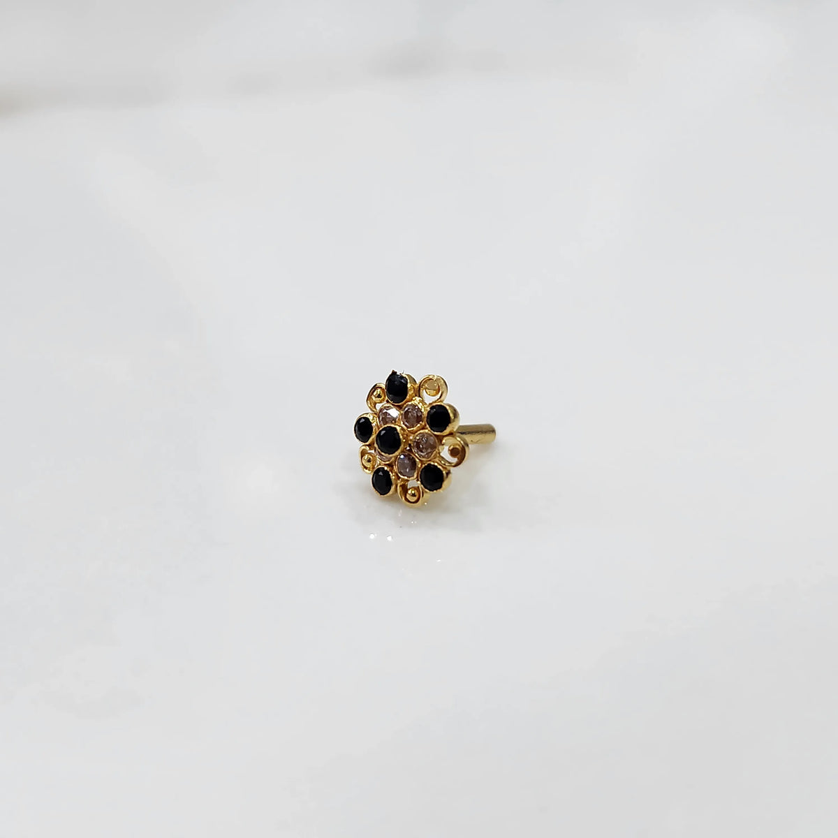 Antique-style gold ring featuring onyx-toned stones in halo design