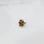 Antique-style gold ring featuring onyx-toned stones in halo design