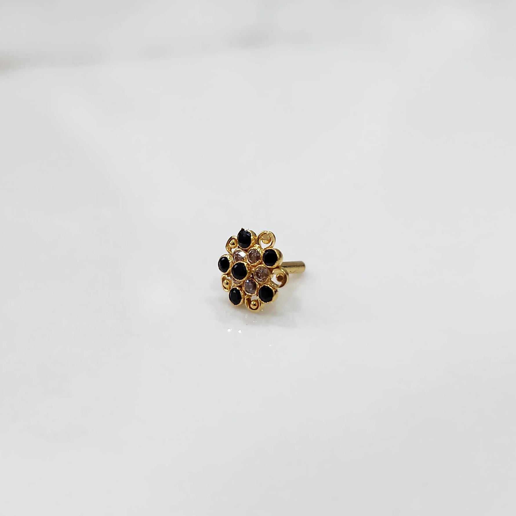 Antique-style gold ring featuring onyx-toned stones in halo design