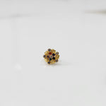 Close-up of gold statement ring with multicolor gemstones in textured flower cluster setting